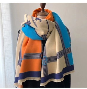 Detail of color-block scarf with equestrian patterns and fine fringe on mannequin