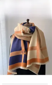 Detail of fine jacquard horse carriage pattern and tassels on cashmere-feel scarf