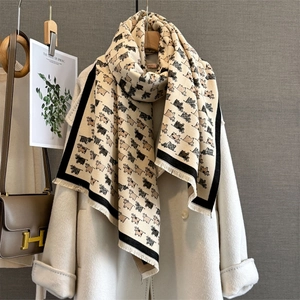 Detailed shot of cream scarf with cat print, black borders, and fine tassel edges