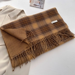 Detail of soft cashmere-like scarf with vintage plaid texture and fringe edges