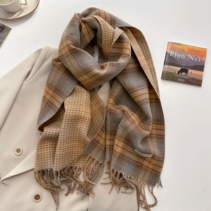 Detail of soft plaid scarf with fringe on a beige blazer for autumn style