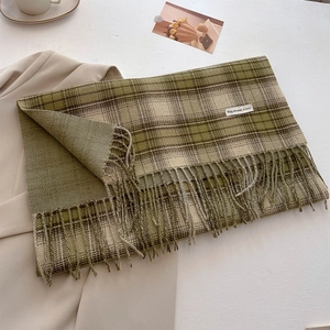 Detail of vintage green plaid cashmere-feel scarf with long tassels and woven label