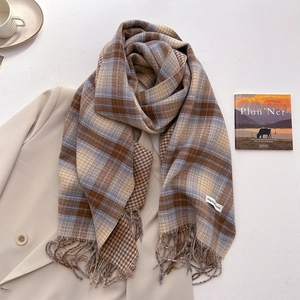 Detail of checkered cashmere-feel scarf with vintage tassels on a beige blazer