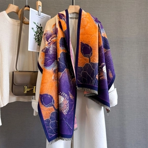 Écharpe jacquard lotus orange et violette avec franges sur un manteau blanc chic