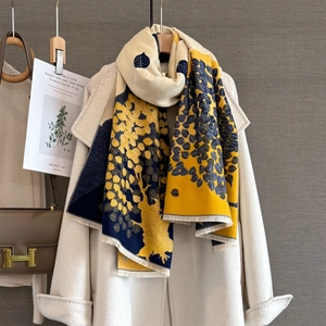 Close-up of abstract leaf jacquard scarf in yellow and navy with delicate fringe trim