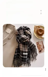 Close-up of classic brown plaid scarf texture with elegant fringed edges and thermal fiber