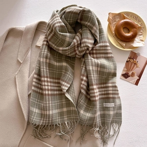 Macro detail of classic green plaid scarf texture and soft tassel fringe trim