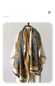 Detail of autumn cashmere-like scarf with letter jacquard, chain pattern and fringe trim