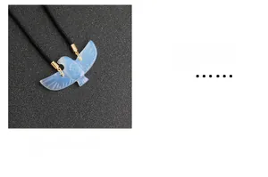 Macro detail of hand-carved blue opalite eagle pendant with golden metal clasp