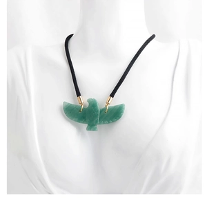 Close-up of eagle pendant in green aventurine stone on a white mannequin bust