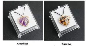 Detail of amethyst and tiger eye heart pendants with gold wire butterfly and packaging
