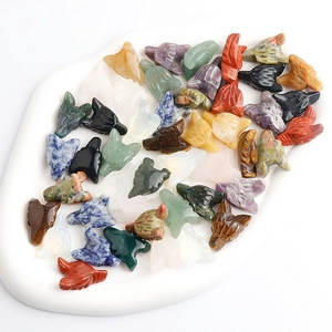 Macro shot of assorted natural crystal wolf heads on white tray showing stone textures