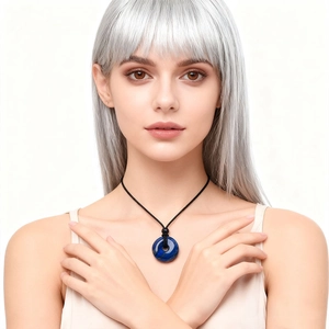 Collana con ciondolo a ciambella in lapislazzuli e cordoncino nero su modella dai capelli grigi