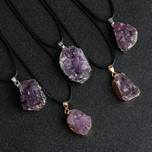 Detailed close-up of natural purple amethyst crystal pendants with gold and silver plated edges