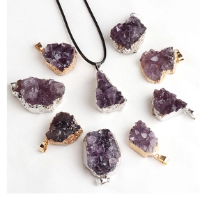 Detail of amethyst crystal pendants with gold and silver plated edges and necklaces