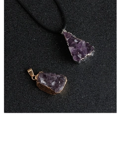 Detailed macro view of raw amethyst cluster pendants with gold and silver plated edges