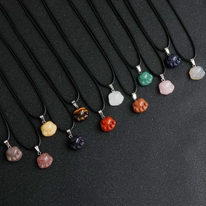 Detailed view of cat paw gemstone pendants in various natural colors with black cords