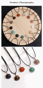 Close-up of cat paw gemstone pendants in various natural stones with black wax cords