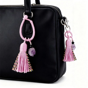 Ciondolo boho con nappe rosa e pietra ametista naturale su borsa in pelle nera