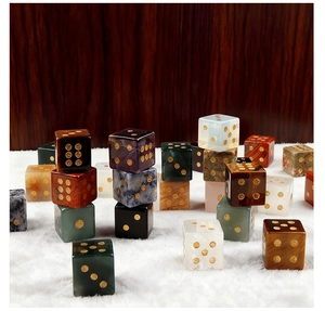 Detail of assorted natural semi-precious stone dice with gold dots on white fur