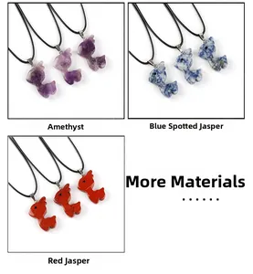 Detailed close-up of fish-shaped natural stone pendants in amethyst, blue spot and red jasper