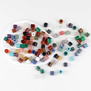 Mix of polished cylindrical natural stone beads for DIY jewelry making on white plate
