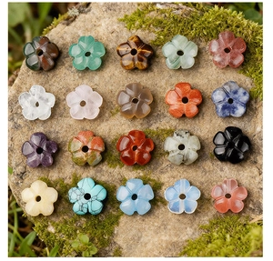 Macro view of assorted flower-shaped natural stone beads displayed on mossy rock