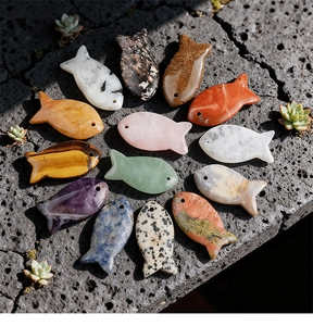 Detailed view of various natural semi-precious gemstone fish charms for DIY jewelry making