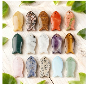 Flat lay of 15 colorful fish-shaped natural stone pendants for DIY jewelry making