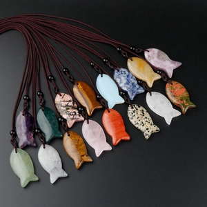 Detailed view of colorful fish-shaped natural stone pendants on woven cords