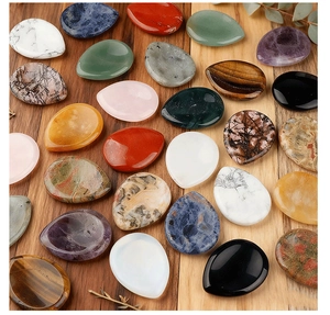 Detailed view of polished thumb stones in amethyst, tiger eye and quartz on wood background
