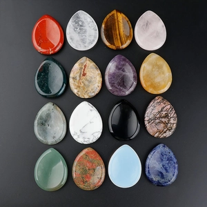 Macro shot of 16 varieties of teardrop-shaped natural crystals and polished gua sha stones