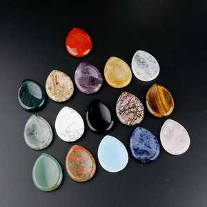 Set of 16 teardrop natural amethyst and gemstone facial gua sha stones on black background