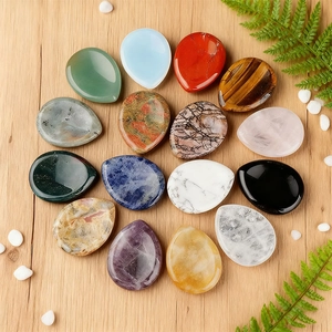 Assorted natural amethyst and quartz teardrop worry stones on a wooden background