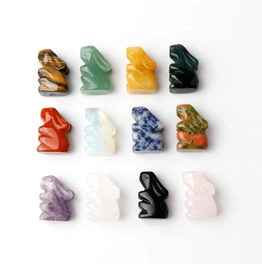 Macro shot of 12 hand-carved crystal rabbit figurines in various natural gemstones