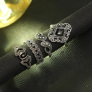 Macro detail of four vintage silver rings featuring black stones and intricate carvings