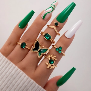 Detailansicht eines 6-teiligen Vintage-Goldring-Sets mit grünen Smaragdsteinen an den Fingern