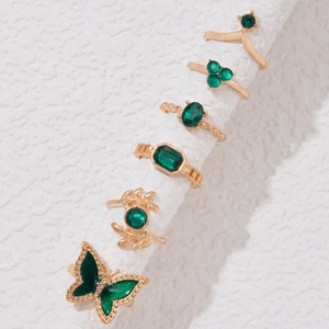 Details von Vintage-Goldringen mit smaragdgrünen Steinen und Schmetterling-Blatt-Motiven