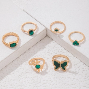 Nahaufnahme des 6-teiligen Vintage-Ring-Sets in Gold mit grünen Steinen und Schmetterlingen