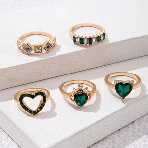 Detailansicht von 5-teiligem Goldring-Set mit smaragdgrünen Steinen und Herzmotiven