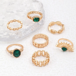 Detail von 7-teiligem Goldring-Set mit künstlichen Smaragden und hohlem Schlangendesign