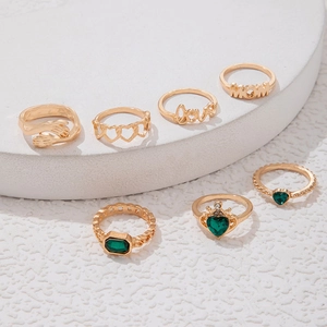 Nahaufnahme goldener Ringe mit smaragdgrünen Steinen und MOM sowie Love Gravur