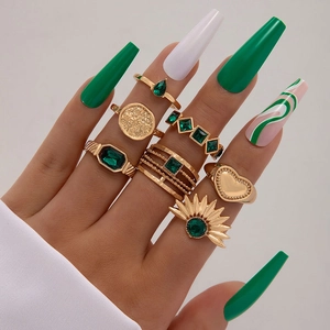 Nahaufnahme von Bohemian Ring-Set mit smaragdgrünen Edelsteinen auf vergoldetem Metall
