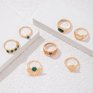 Detailansicht des 7-teiligen Vintage-Goldring-Sets mit grünen Edelsteinen und Herzmotiven