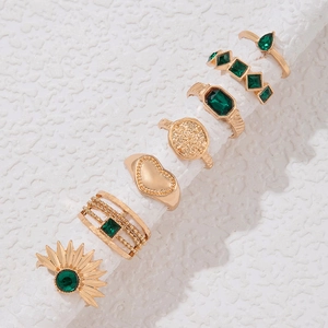 Detailansicht eines 7er-Set Goldringe mit smaragdgrünen Edelsteinen und Herz-Motiven