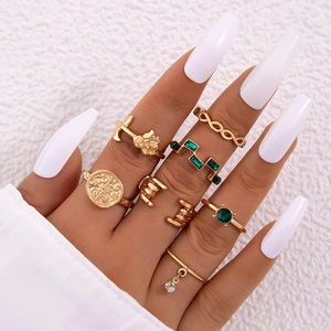 Nahaufnahme von Vintage-Goldring-Set mit künstlichem Smaragd und Boho-Gravur-Details
