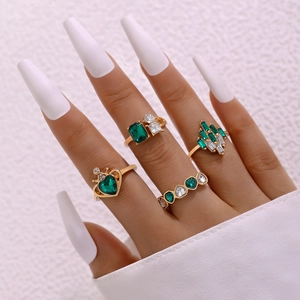 Detail von Vintage-Ring-Set vergoldet mit smaragdgrünen Edelsteinen an einer Hand