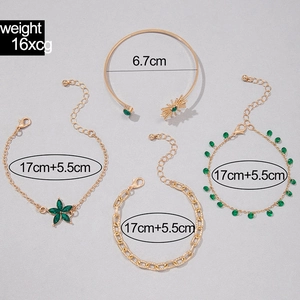 Détail d'un ensemble de 4 bracelets dorés avec pierres émeraude et motifs de soleil