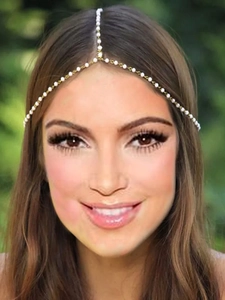 Exotic pearl forehead chain with gold links and crystals on a bohemian headpiece