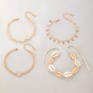 Detail view of shell anklet set with golden alloy chains and natural scallop pendants